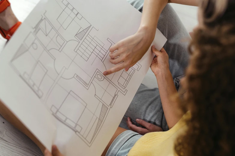 people holding a book with a drawing on it