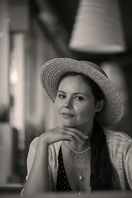 woman in white hat sitting at a table