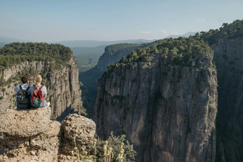 a couple of people that are sitting on top of a hill