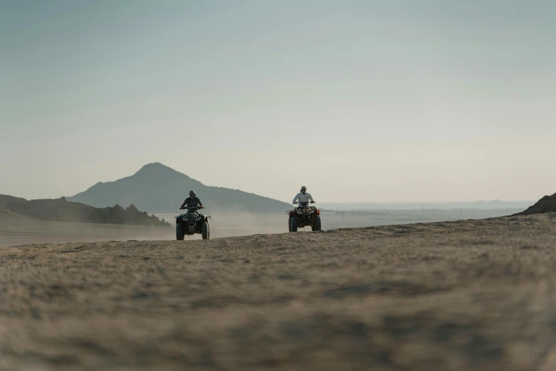 two people riding on the back of horses in the desert