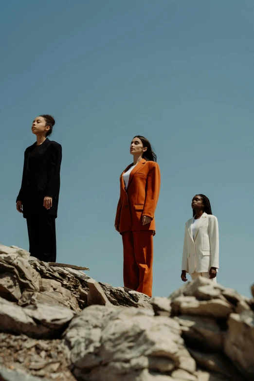 three men in different outfits on rocks on a sunny day