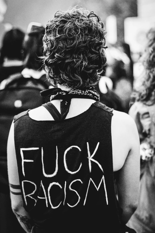 a man in a vest with the words  racism written on it