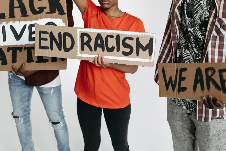 people holding black lives matter signs and one with an orange shirt