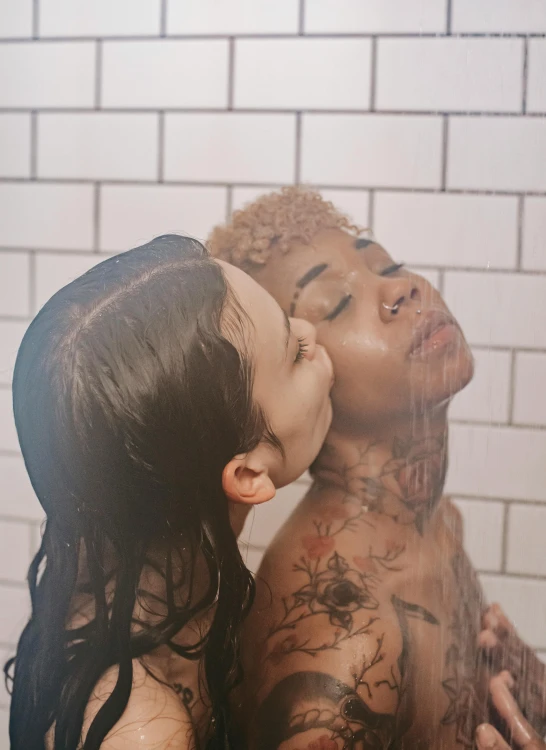 an image of a couple with tattoos on them kissing