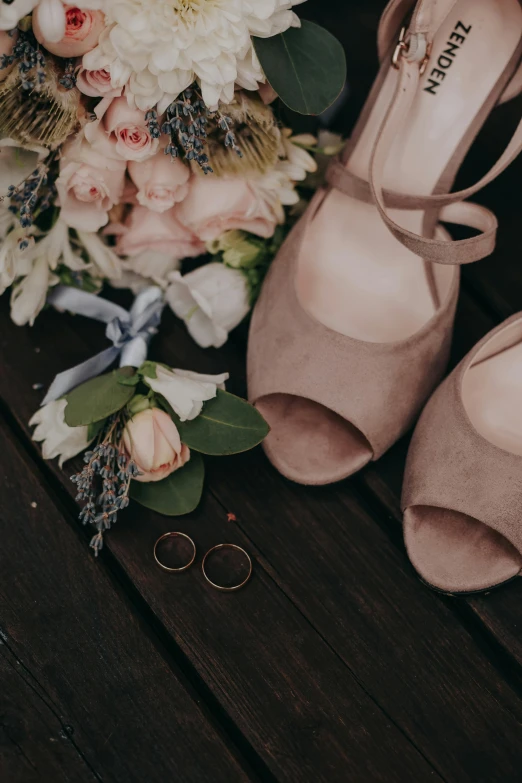 a pair of shoes and an bouquet of flowers on a table