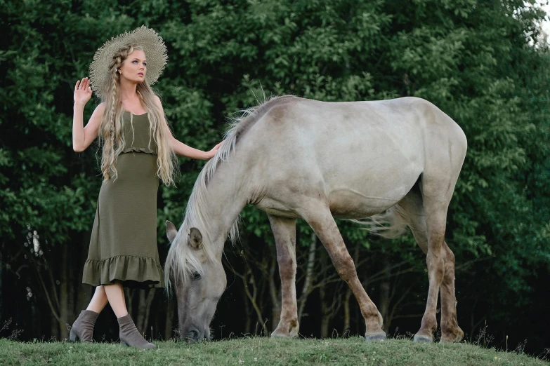 woman dressed as native american, standing next to horse with native headpiece