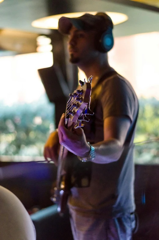 a man with a guitar playing music indoors