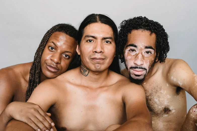 three  guys posing with one shirtless