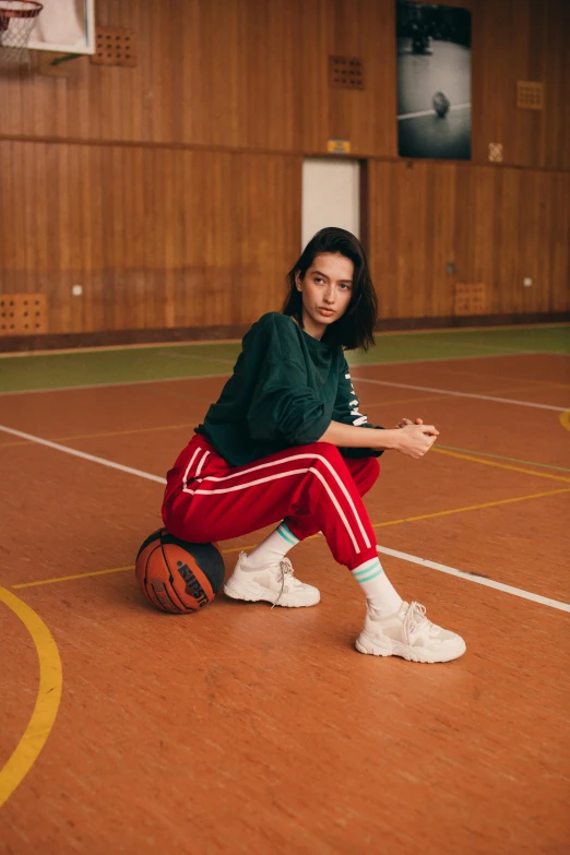 a young woman is holding a basketball in a gym