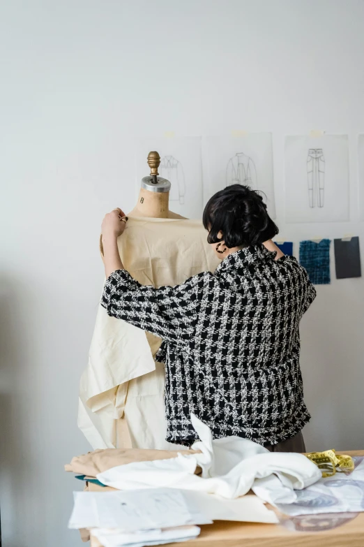 woman working on fabric at desk with lamp