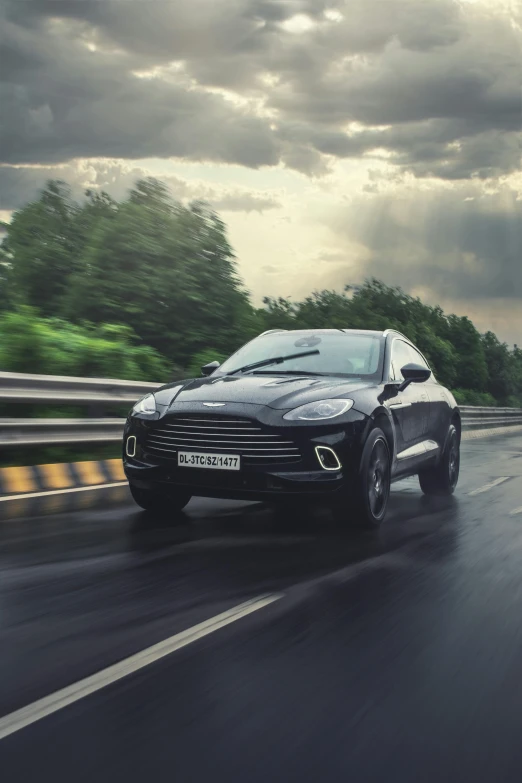 a suv driving down a road in front of clouds