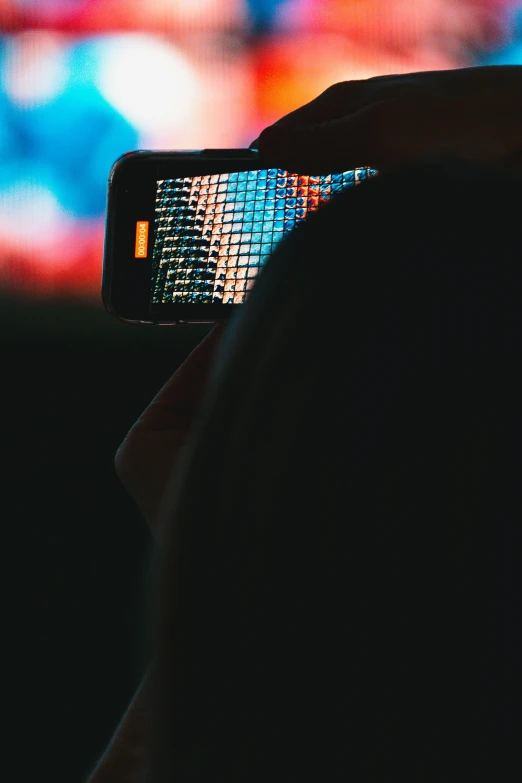 a dark image of someone looking at their cell phone