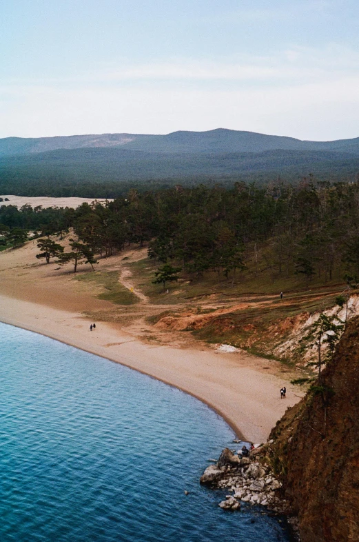 the view from above shows trees and people on a path that leads to an ocean