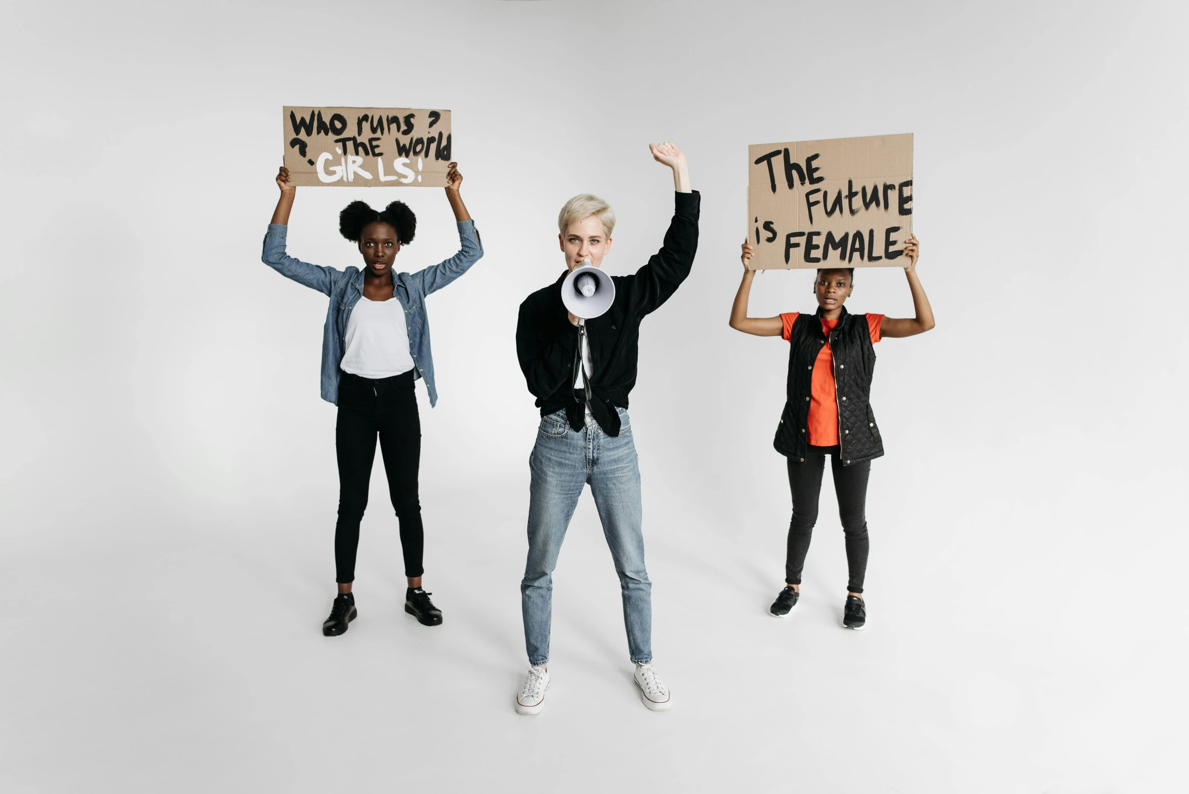 three people holding signs in the same direction