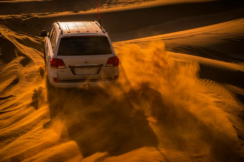 an suv drives in the desert at dusk