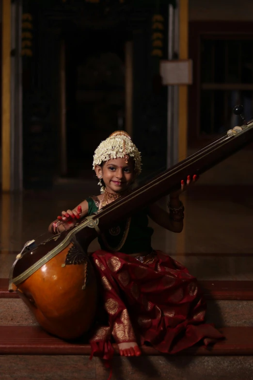 a  in a turban and headdress plays an instrument