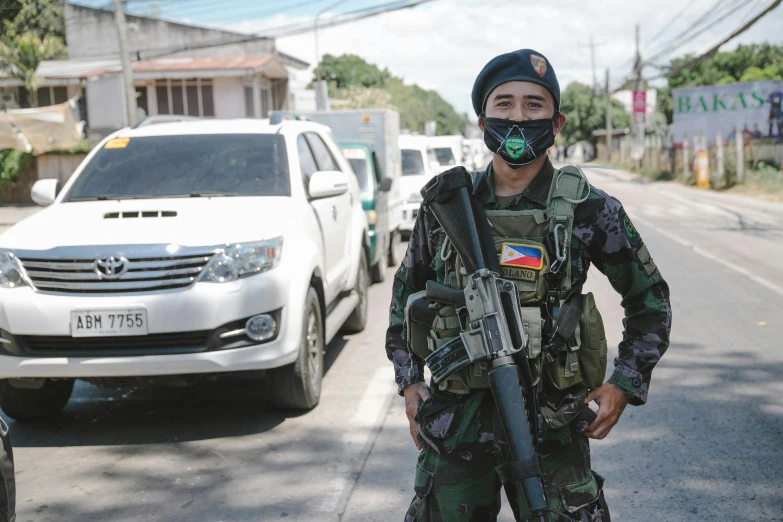 a soldier holding a rifle is standing in the street