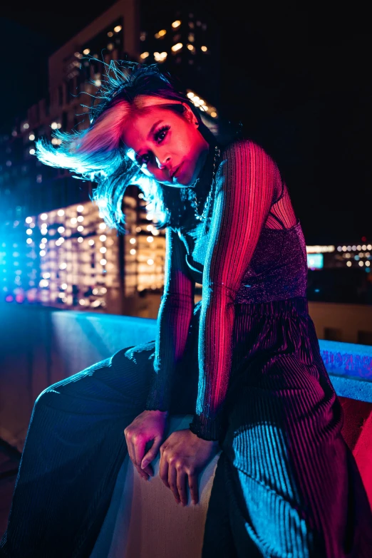 a woman sitting on the edge of a ledge next to a street