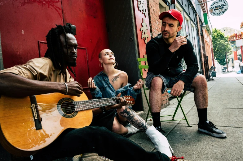 a group of people sit in front of a red wall