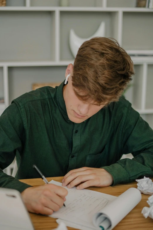 a man sitting at a table with his handwriting on it