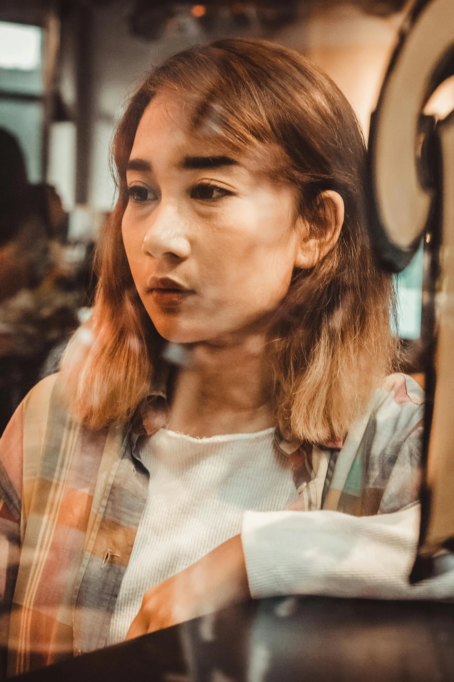 a young woman sitting at a table in front of a mirror