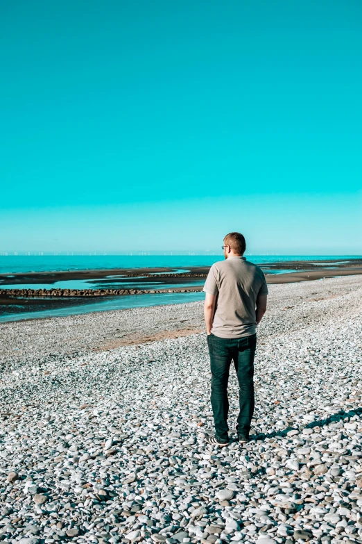 a person standing on the beach looking out towards the ocean