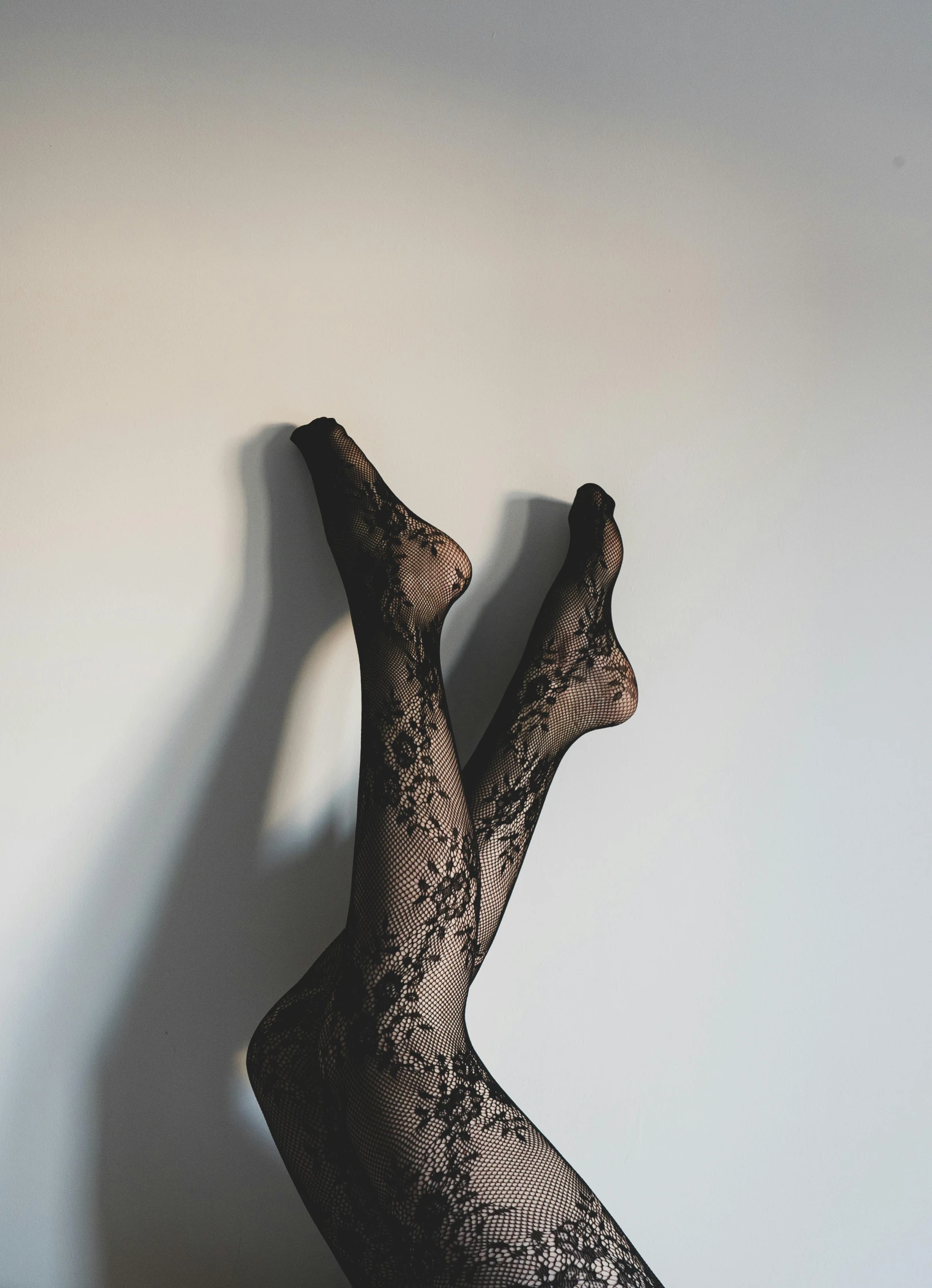 a womans black stockings is hanging up on a white wall