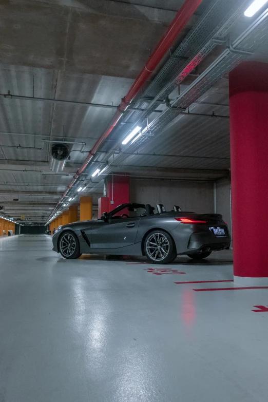 a black convertible car parked in an underground parking garage