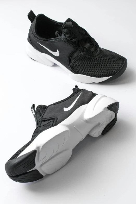 a pair of black and white sneakers on top of a white surface