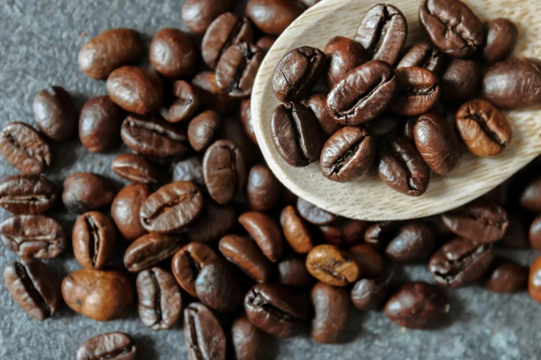 a spoon with coffee beans on it