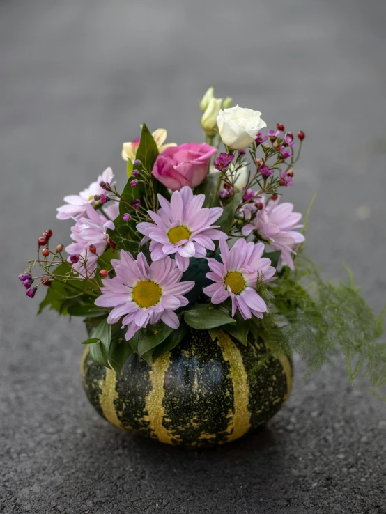 a bowl holding colorful flowers sitting on top of a table