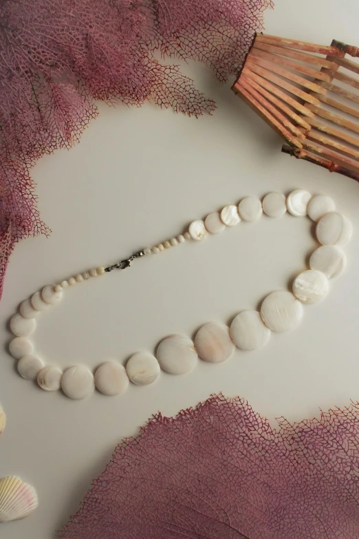 two different items, including beads and a wooden comb are on a purple background