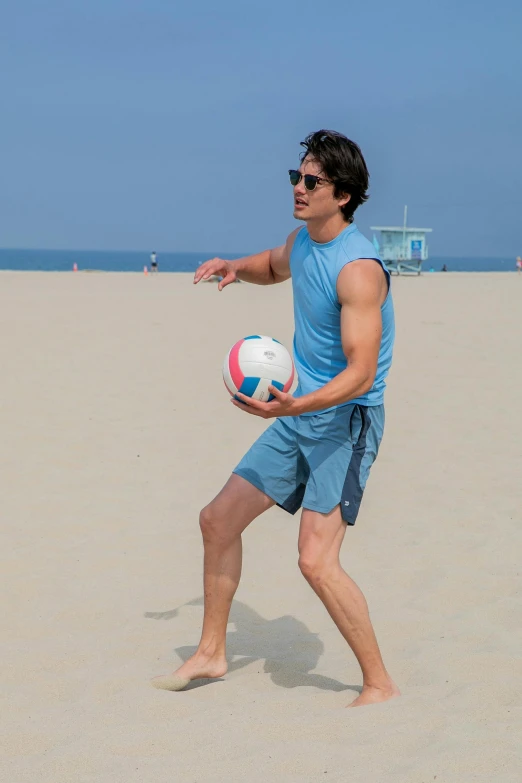 a man playing with a soccer ball on the beach