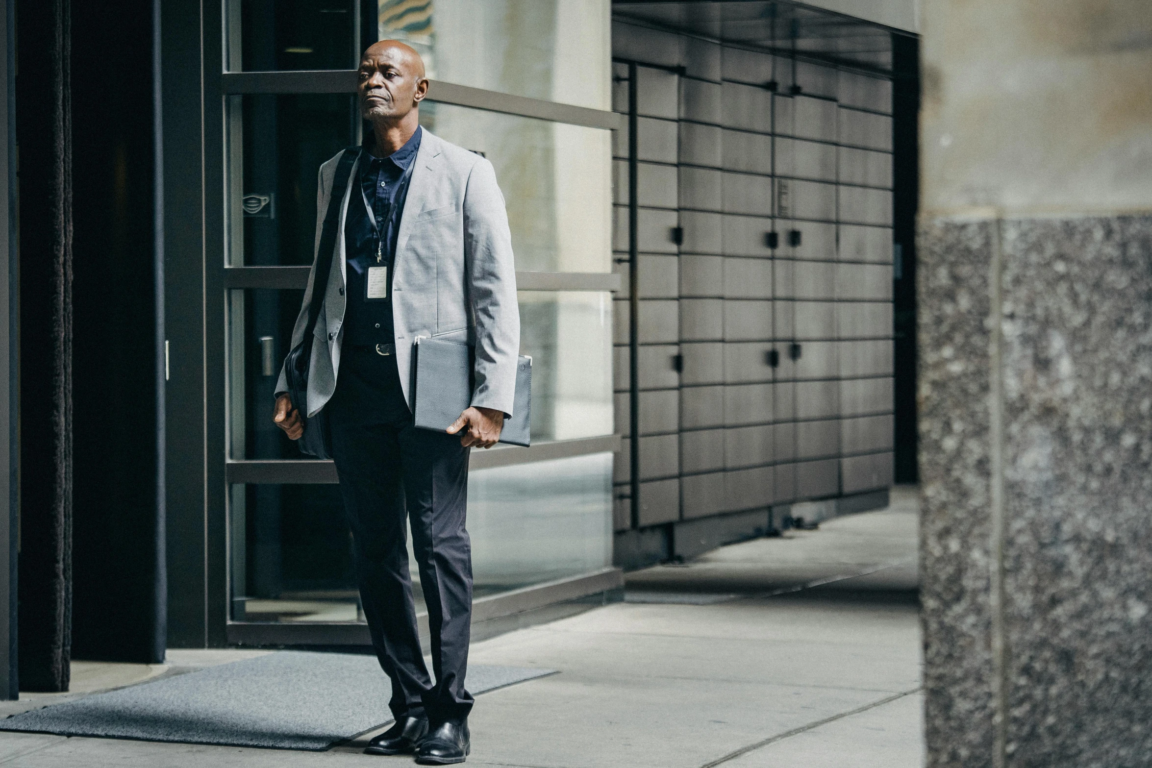 a man standing on the side walk near a building