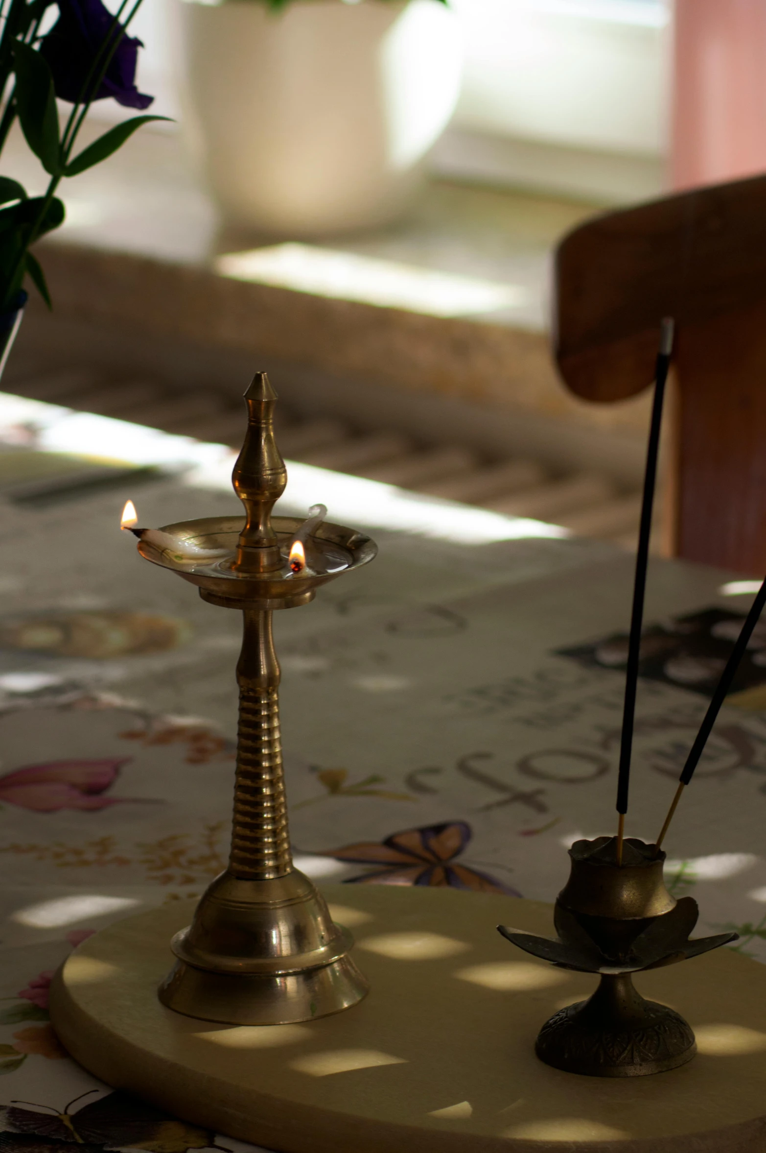 a candle stand in front of a cross on a table