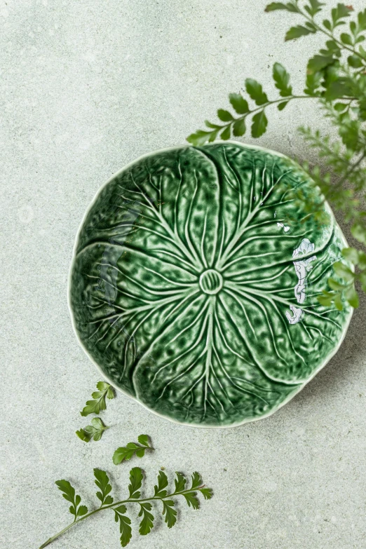 a small bowl with a leaf on the surface