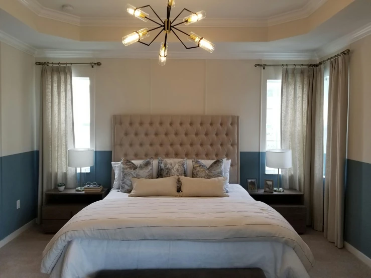 a bedroom with white and blue accents and a chandelier