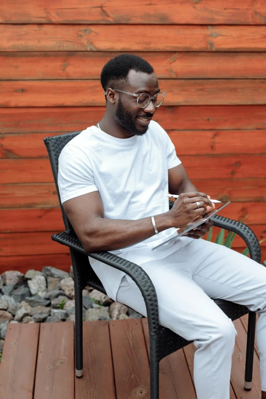 a man sitting in a chair on his laptop