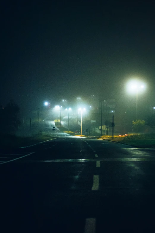 an empty intersection with no traffic in the rain at night