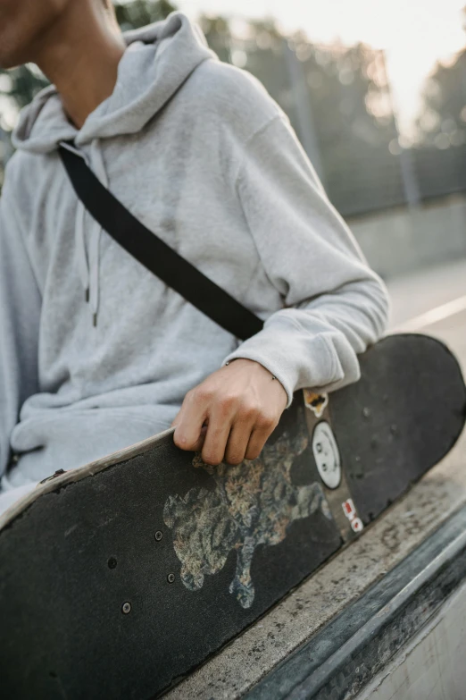 a skateboarder is sitting on a ledge holding his board