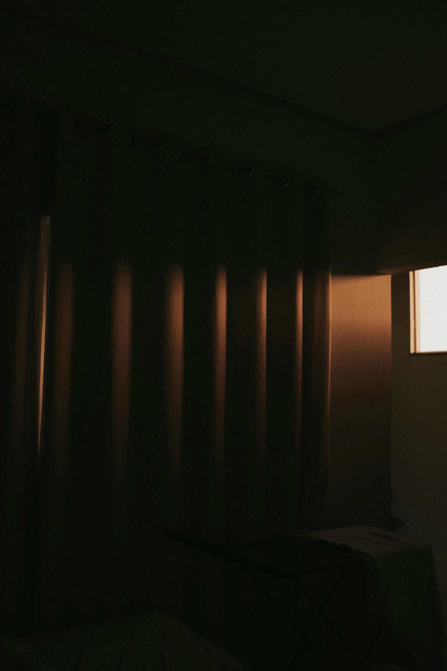 a bed sitting next to a window in a dark room