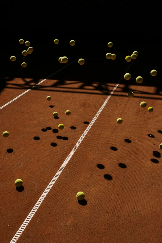 there is many tennis balls all over the court