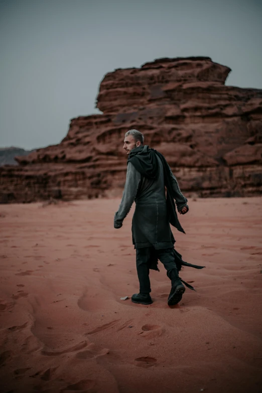 the man with a backpack walks in desert