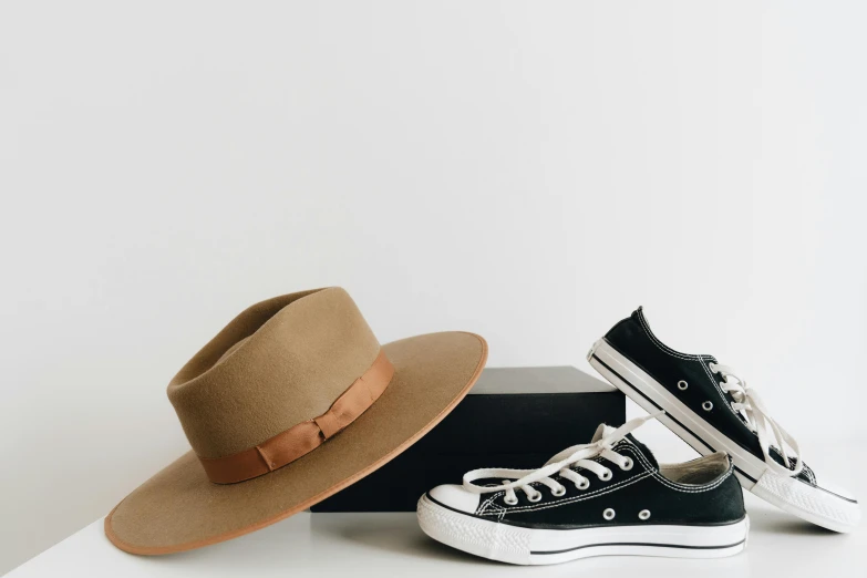 two pairs of shoes with a hat on top of them