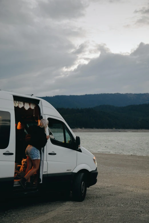 a man and a woman looking into the van