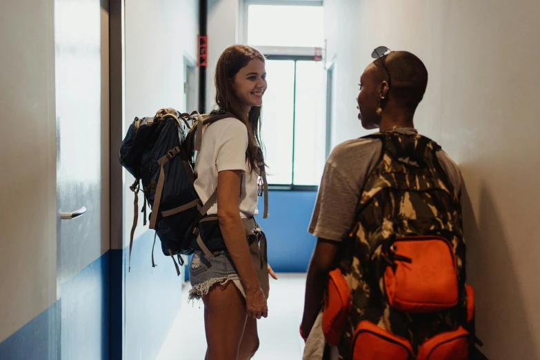 two girls are standing in the hallway of an apartment