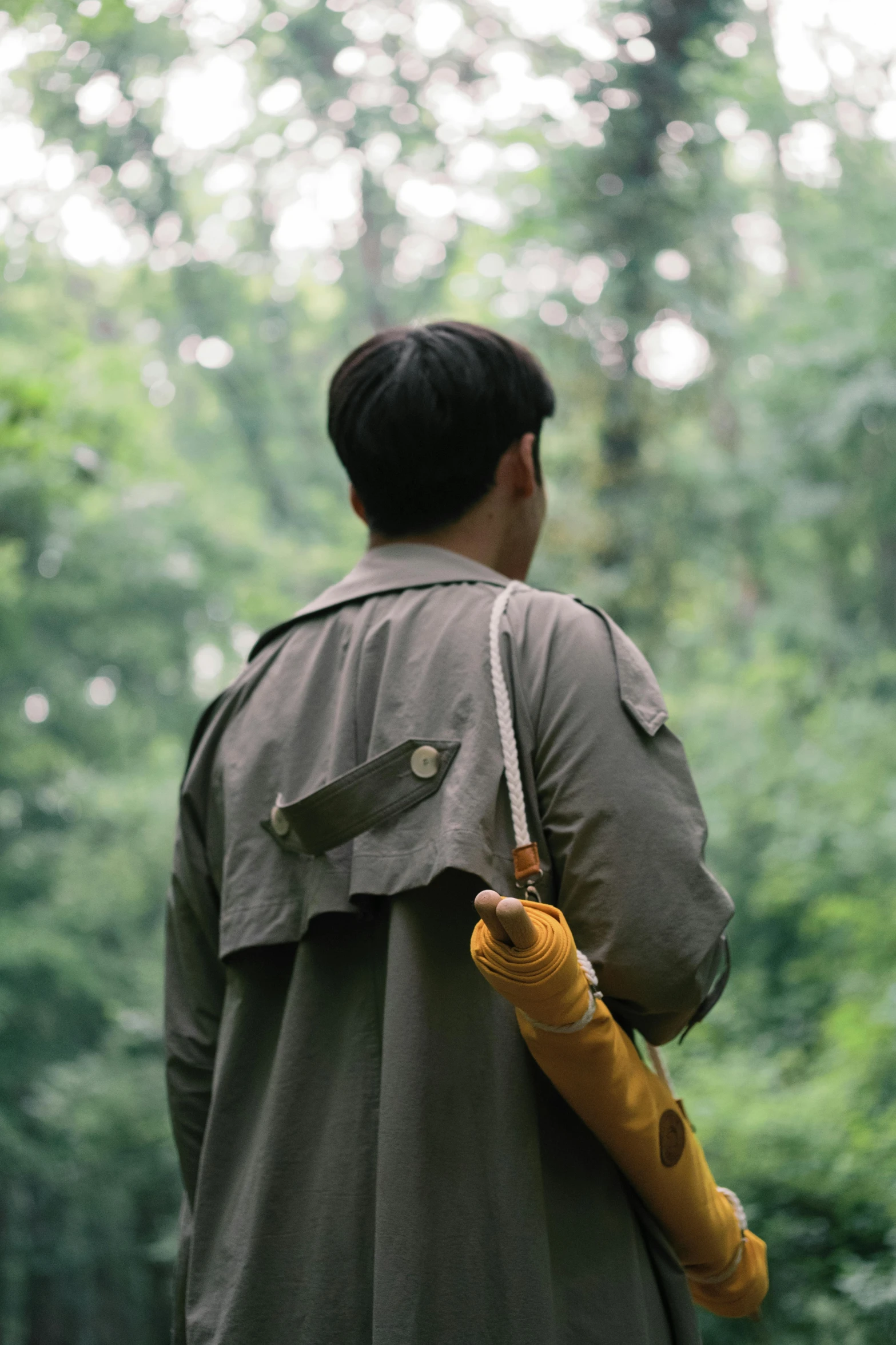 a man wearing a trench coat and holding a umbrella in the rain