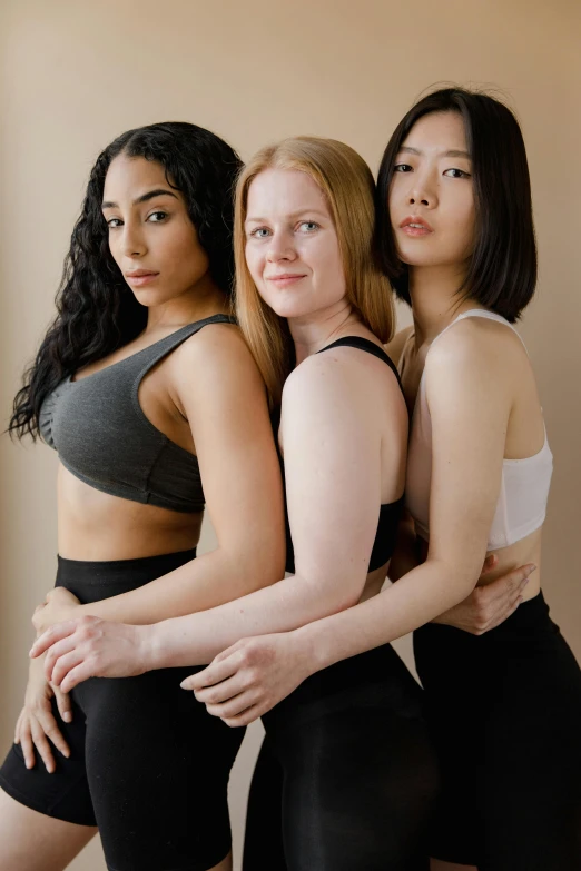 three beautiful women in black clothing posing for the camera