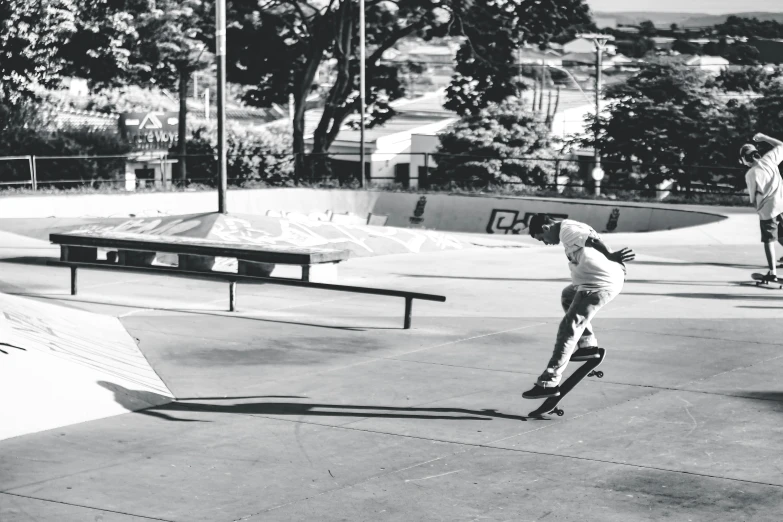 two boys riding skateboards on a large cement area