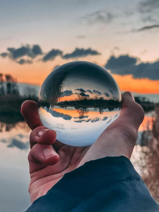 a person holds a glass ball in their hand